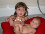 Child and baby in a Batya having a bath together